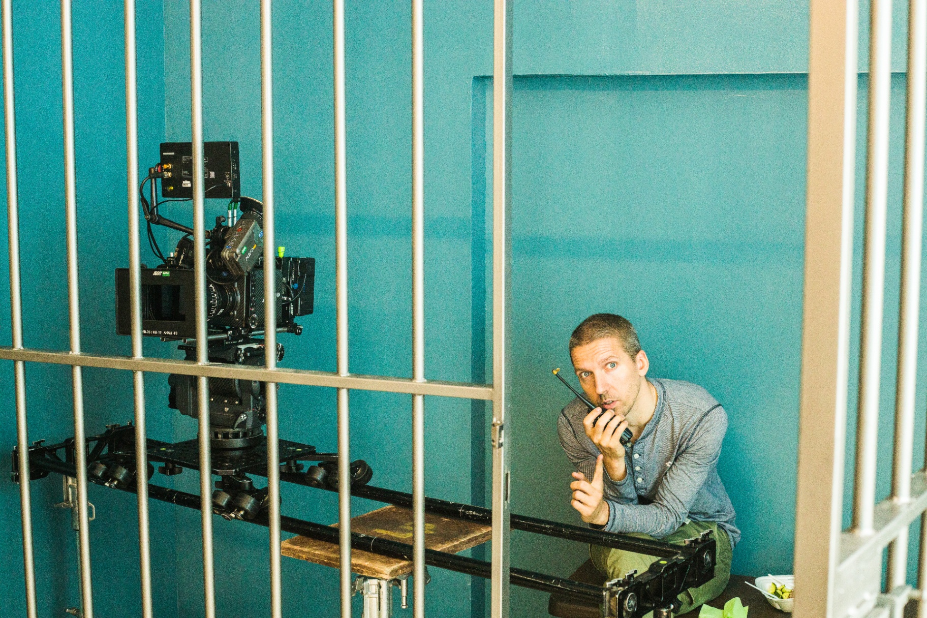 Director on comms beside the dolly inside a cell set