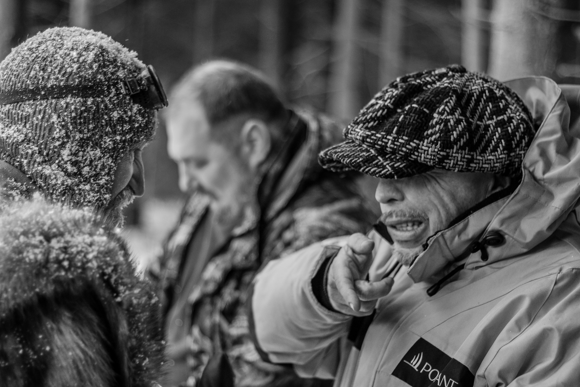 Frost-covered crew in conversation on a winter set